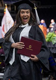 Student celebrating with diploma at commencement